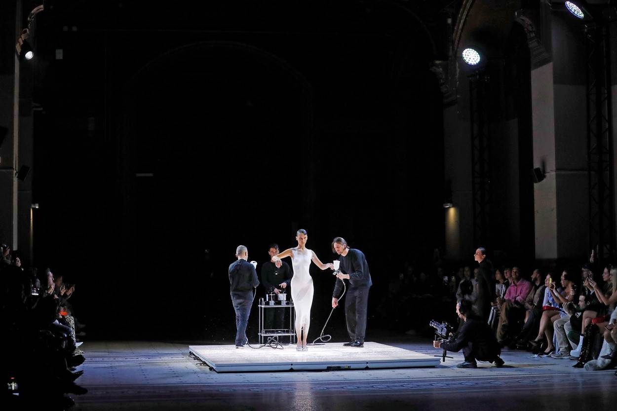 Na sinoćnoj reviji na Nedelji mode u Parizu, na reviji Coperni na manekenku Belu Hadid bukvalno su naprskali haljinu, a potom je rukama oblikovali. 